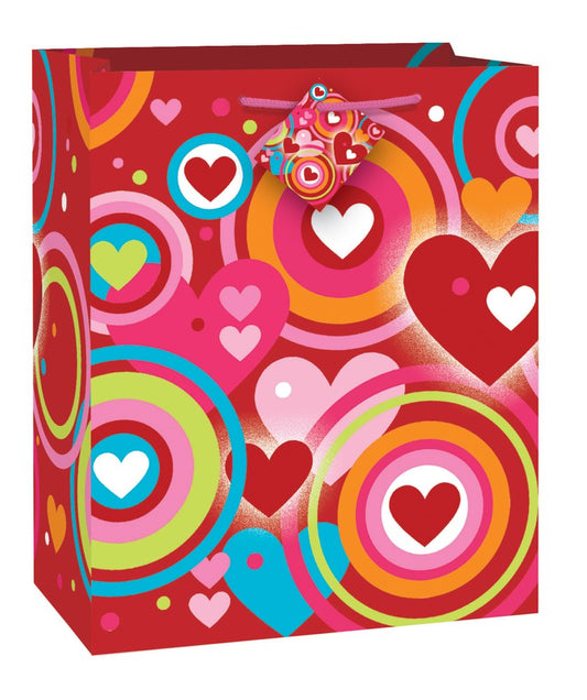 Red Valentine-themed gift bag with colorful concentric hearts and circular patterns in pink, orange, blue, and white.