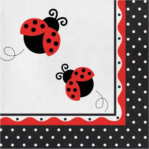 White napkin with two red and black ladybugs and black polka dot border with red scalloped edge.