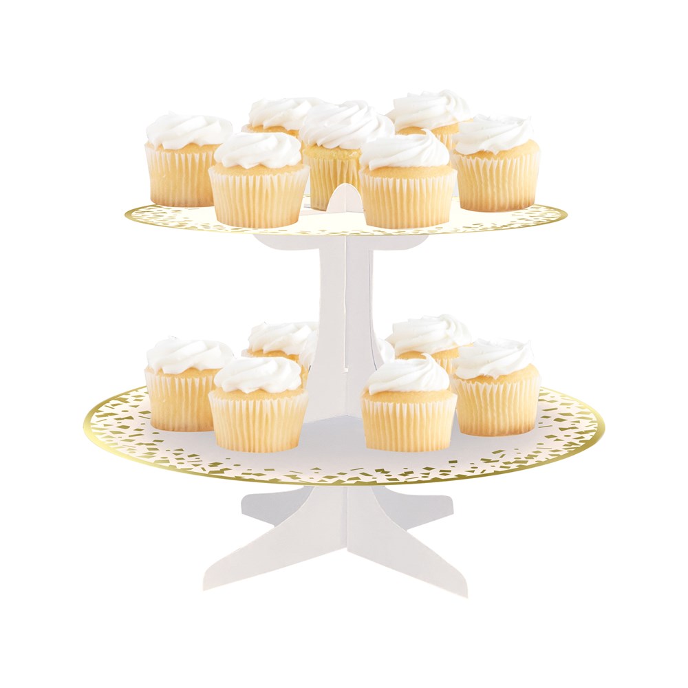 Two-tier white cupcake stand with gold polka dots, holding vanilla cupcakes with white frosting.