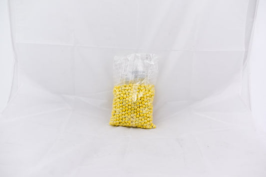 Clear plastic bag filled with small bright yellow round pellets labeled Shimmer SiXLets.