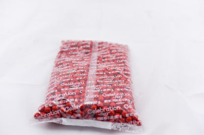Clear plastic bag filled with small red round candies labeled SiXLets Celebration, weighing 2 pounds.