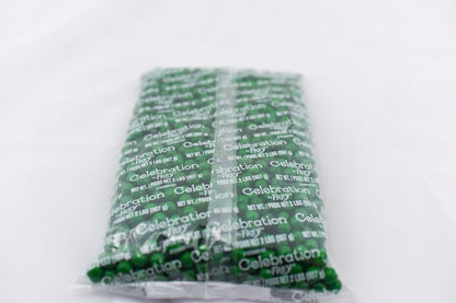 Dark green rectangular bag with white celebratory text pattern, containing small pellets or nuggets.
