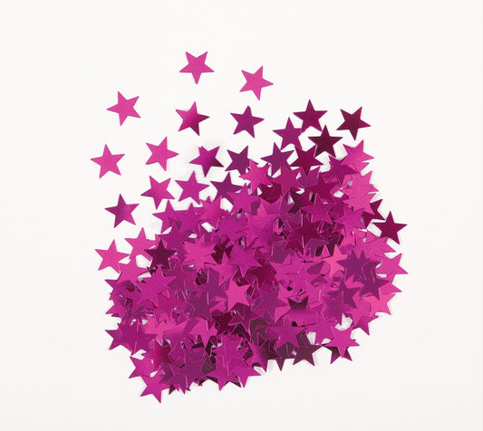 Pink metallic star-shaped confetti scattered on a white surface.