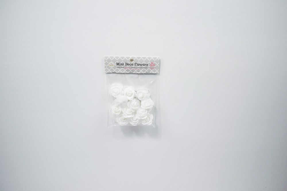 Package of 12 small white foam flowers with layered petals, 1 3/4 inches wide, for party decoration.