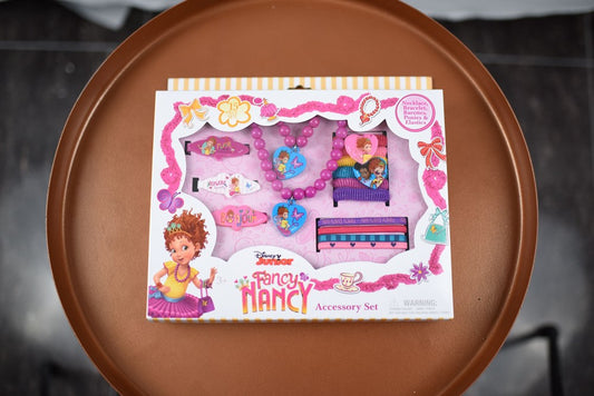 Girls' Fancy Nancy accessory jewelry set with pink, purple, and blue toy jewelry pieces in decorative white and pink.