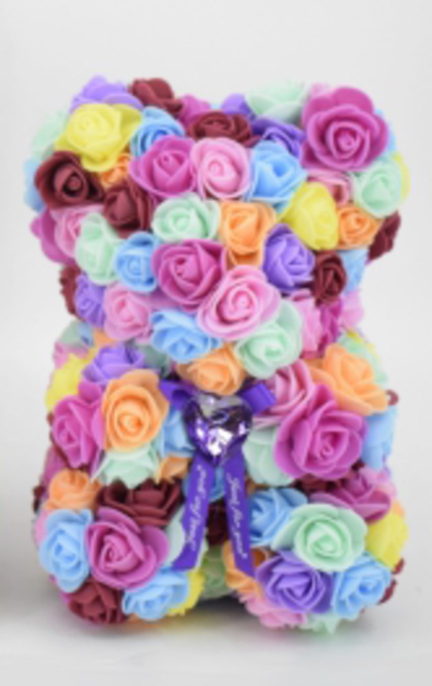 Teddy bear shape made of colorful foam roses in pastel shades with a purple ribbon bow at the neck, 9.5 inches tall.