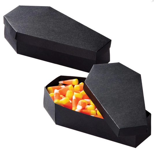Black cardboard coffin-shaped treat boxes with removable lids, one filled with candy corn.