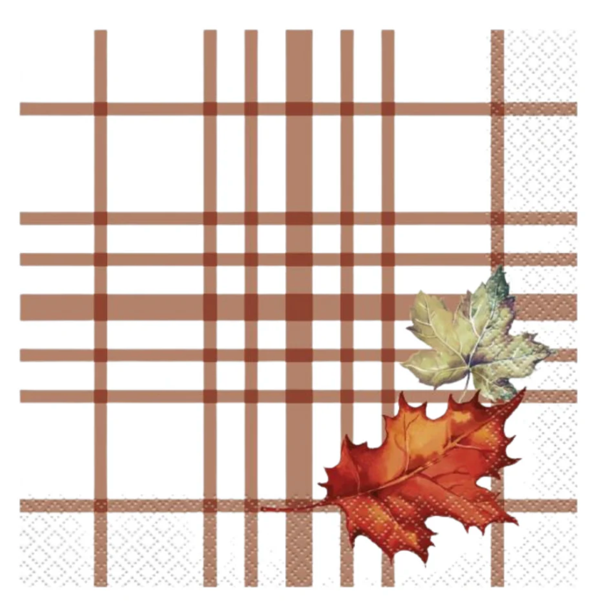 White lunch napkin with brown plaid lines and printed orange and green autumn leaves in corner.