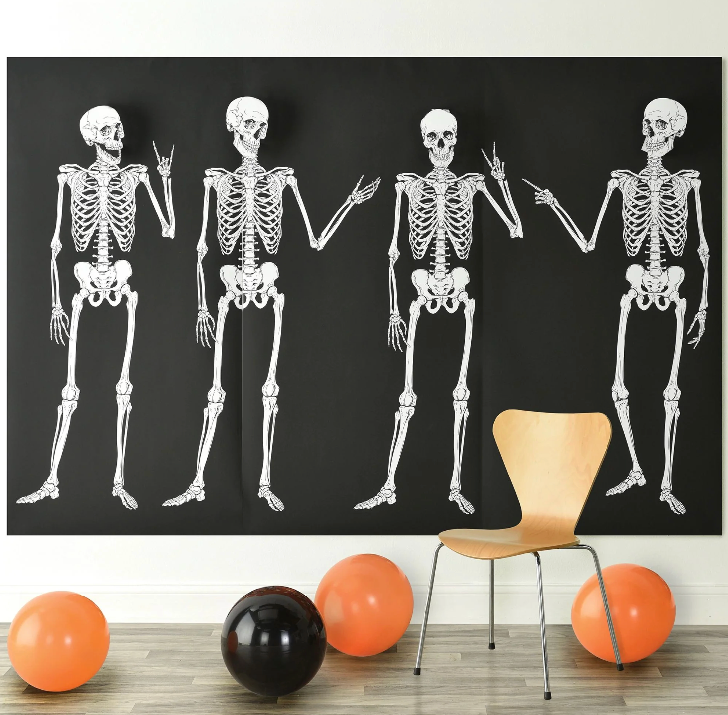 Three white skeleton backdrops on black panels with four full skeletons holding hands, surrounded by orange and black.