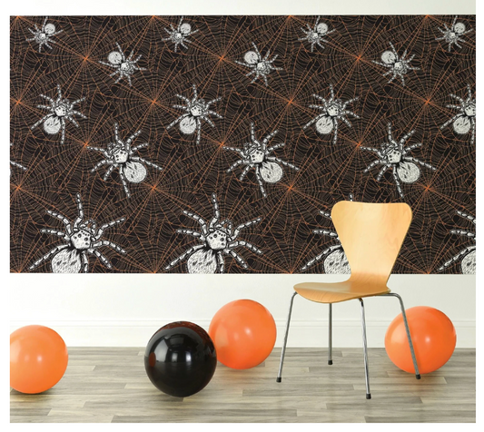 Black and orange Halloween room roll with white spider patterns, hung on wall above scattered orange and black balloons.