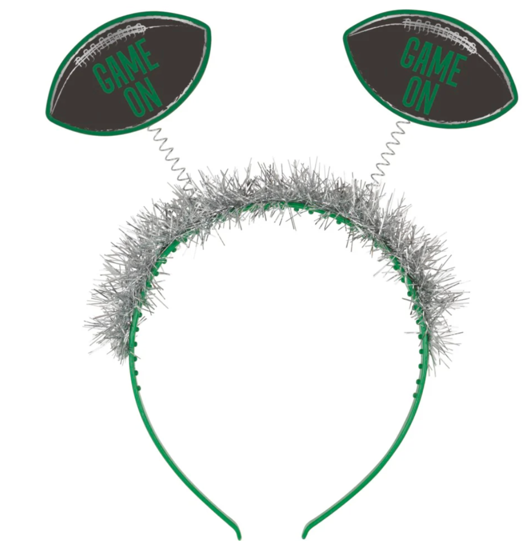 Silver tinsel headband with green-edged black football shapes reading "Game On" on spring antennas.