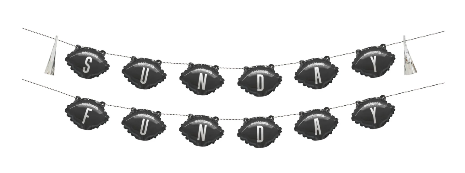Black football-shaped foil balloons spelling "SUNDAY FUNDAY" in white letters, strung as a banner with gold tassels on each.