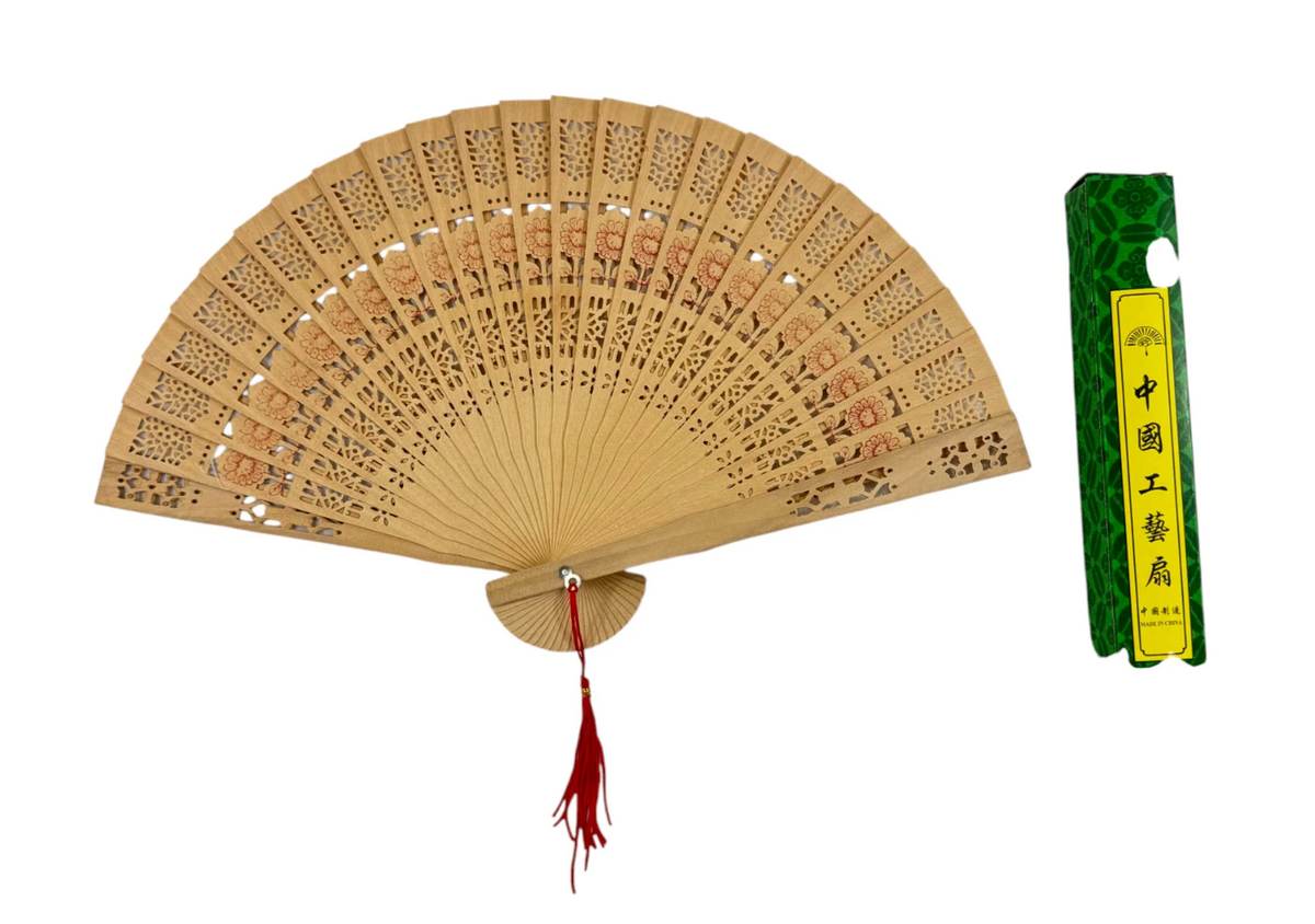 Light brown wooden folding hand fan with intricate cutout patterns and a red tassel, packaged in a green decorative box with