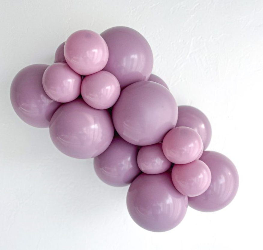 Cluster of matte latex balloons in dusty rose and mauve shades, various sizes forming a decorative arrangement.