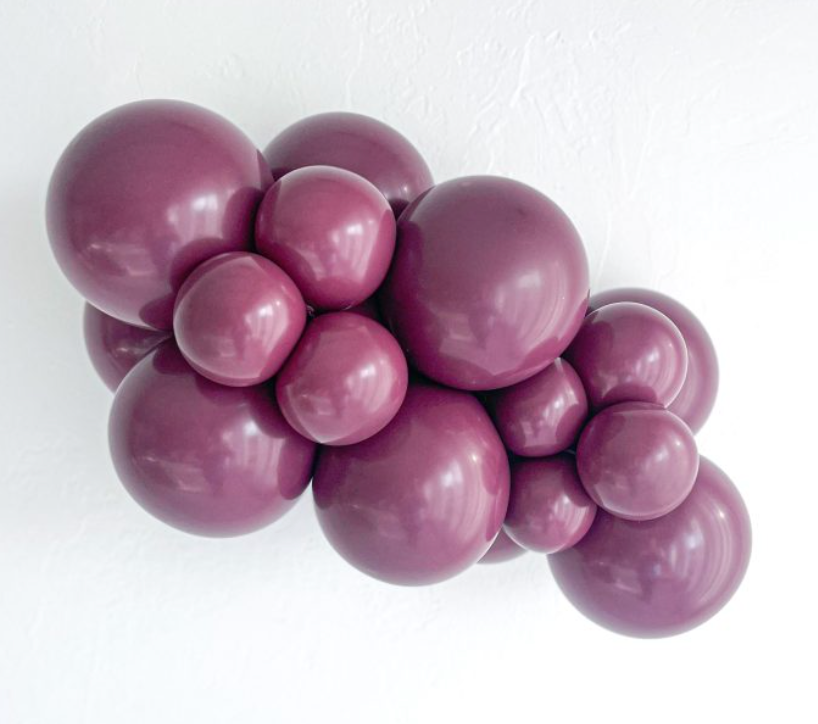 Cluster of glossy sangria-colored latex balloons in varying sizes, arranged tightly together.