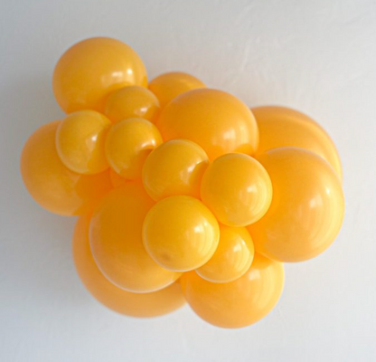 Cluster of shiny goldenrod yellow latex balloons in various sizes with smooth surfaces.