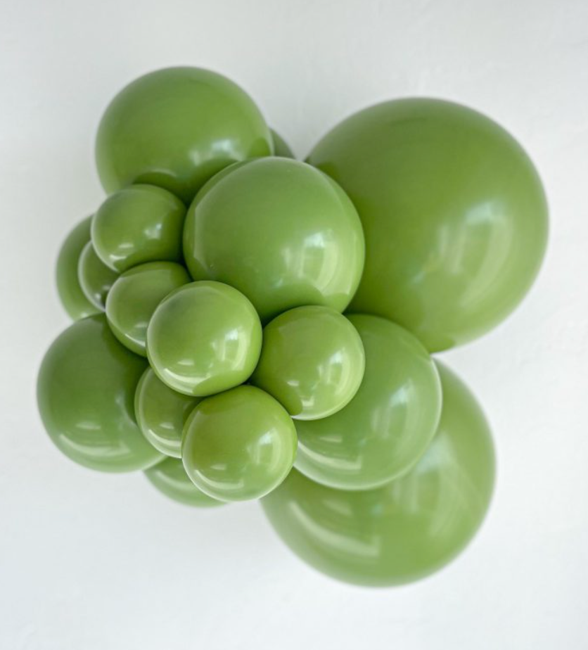 Cluster of shiny green latex balloons in various sizes, inflated and arranged closely together.