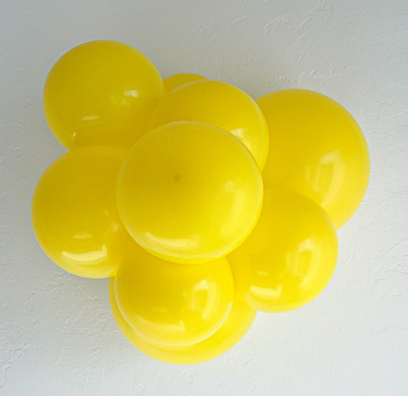 Cluster of shiny, round yellow latex balloons inflated to 24 inches against a white background.