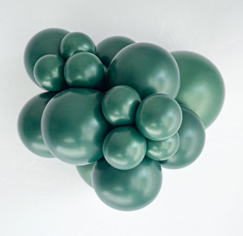 Cluster of metallic forest green latex balloons in varying sizes grouped tightly together.