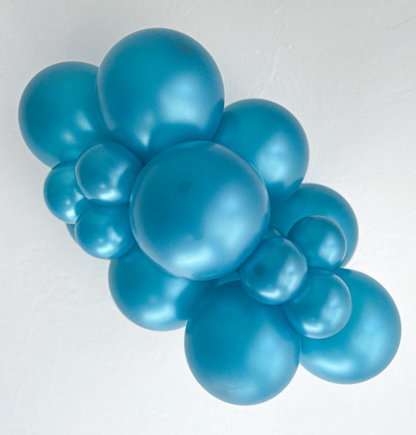 Cluster of shiny metallic teal latex balloons inflated in various sizes against a white background.