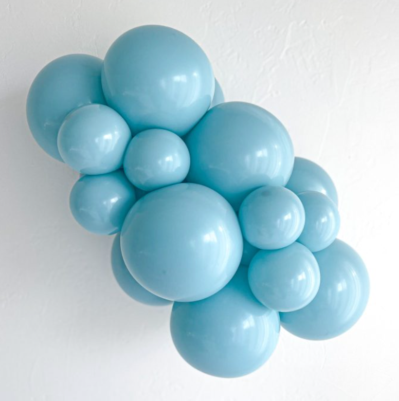 Cluster of shiny light blue latex balloons in various sizes arranged closely together against a plain white background.
