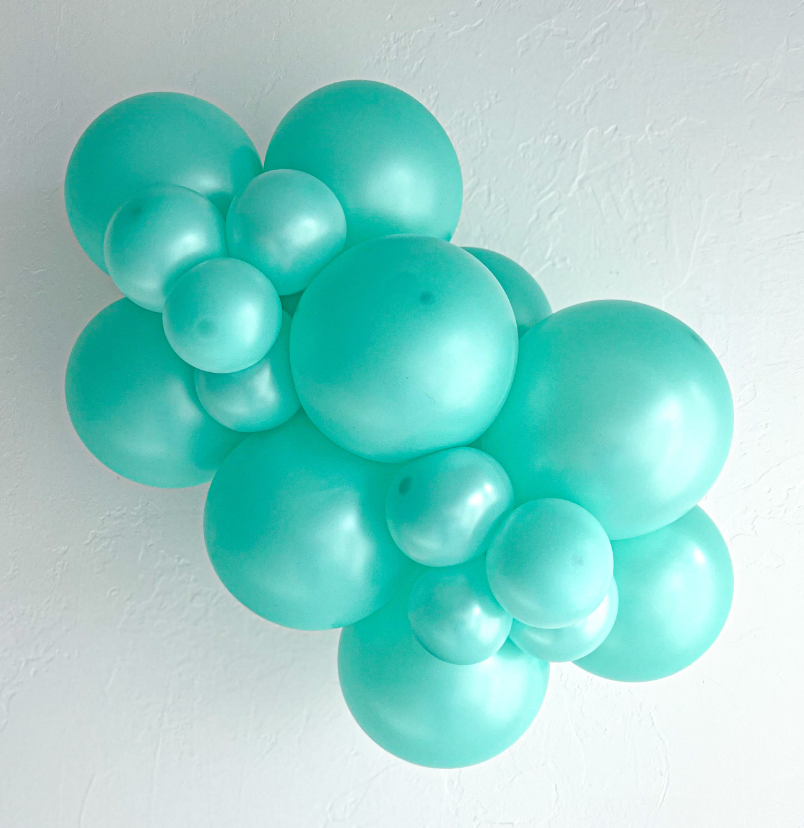 Cluster of glossy pearlized seafoam green latex balloons in varying sizes forming a decorative arrangement.