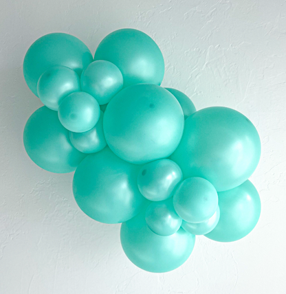 Cluster of glossy pearlized seafoam green latex balloons in varying sizes forming a decorative arrangement.