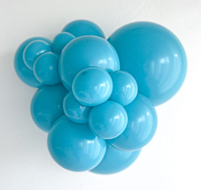 Cluster of shiny turquoise latex balloons in various sizes inflated and grouped together.