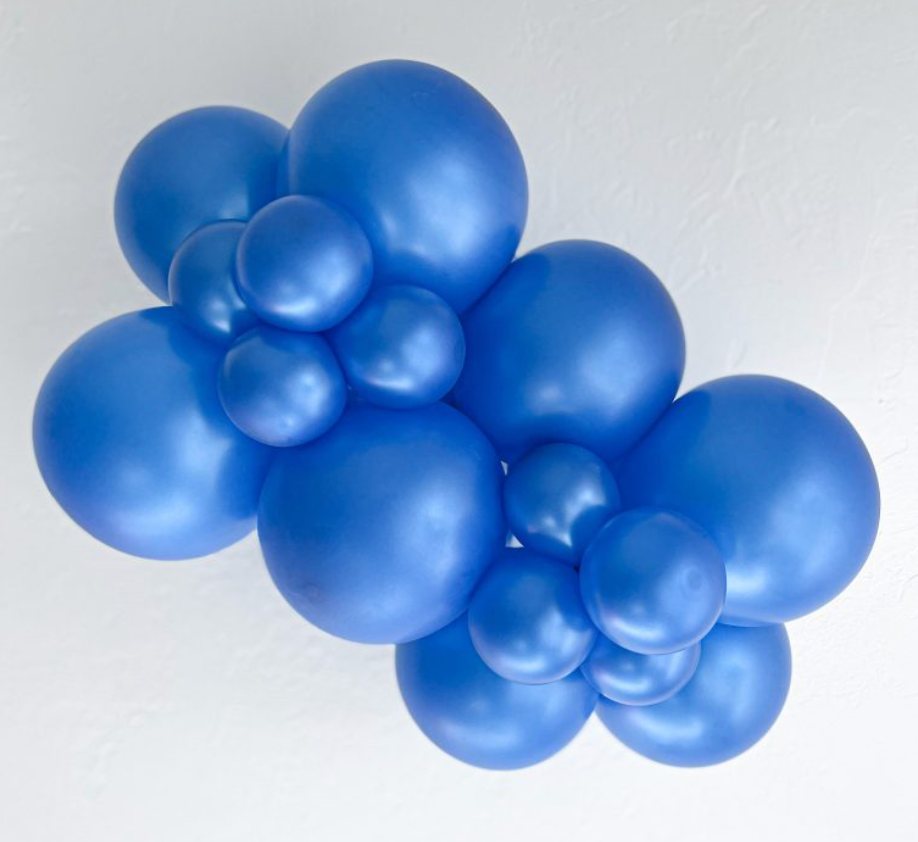 Cluster of metallic blue latex balloons in various sizes, inflated and arranged together.