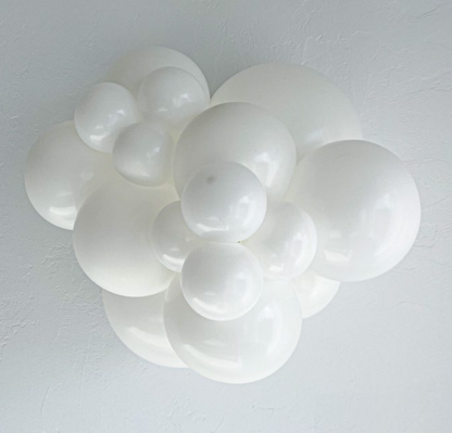Cluster of glossy white latex balloons in various sizes, inflated and arranged closely together.