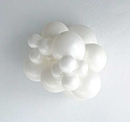 Cluster of matte white latex balloons in various sizes forming a decorative arrangement.