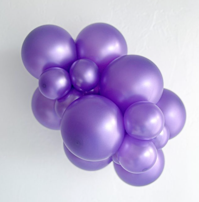 Cluster of metallic lilac latex balloons in various sizes with a smooth, shiny surface.