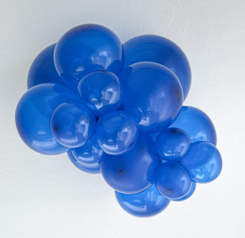 Cluster of glossy crystal sapphire blue latex balloons inflated to various sizes, showcasing smooth, round shapes and.