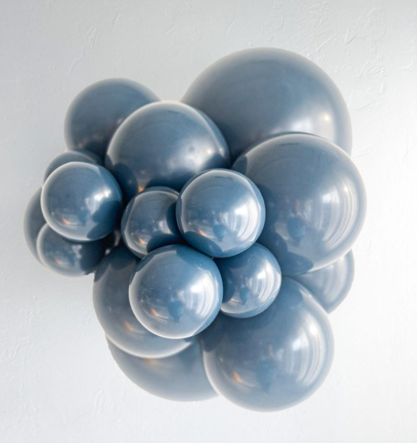 Cluster of glossy blue latex balloons in various sizes arranged closely together.
