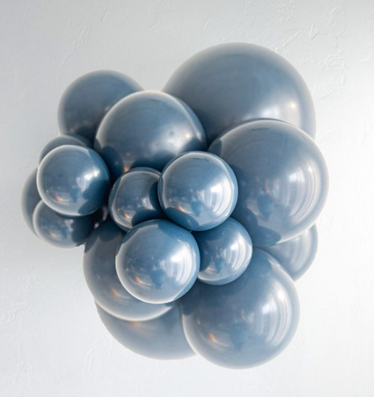 Cluster of glossy blue latex balloons in various sizes arranged closely together.