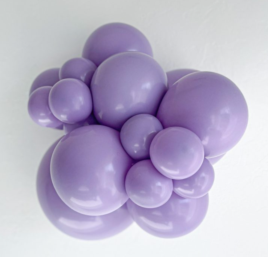 Cluster of shiny purple latex balloons in various sizes forming a rounded arrangement.