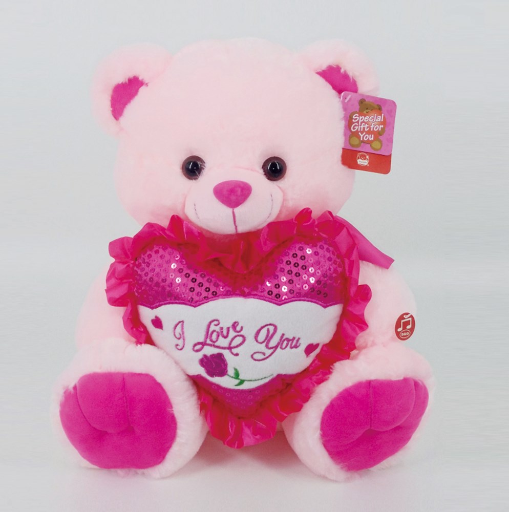 Soft pink plush bear holding a pink sequined heart with "I Love You" embroidered in white and red accents.