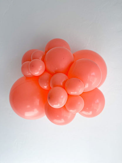 Tuftex Coral latex balloon color cluster showing the shade across multiple balloon sizes