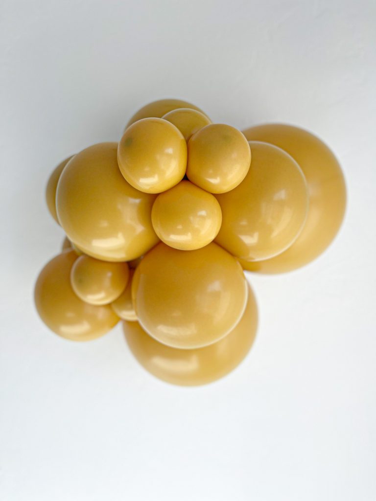 Tuftex Mustard latex balloon color cluster showing the shade across multiple balloon sizes