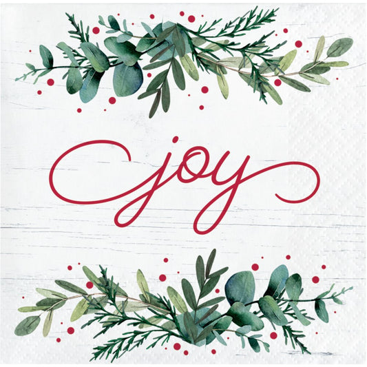 White beverage napkin with red "joy" script and green eucalyptus and pine leaf garlands with red berries.